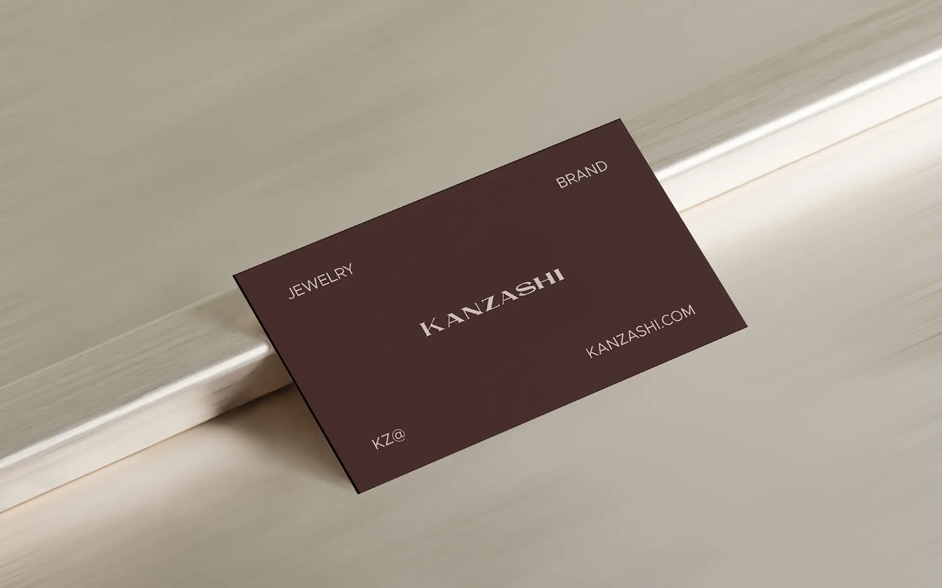 Business card design for Kanzashi Japanese jewelry brand showing logotype and brand identity on maroon card